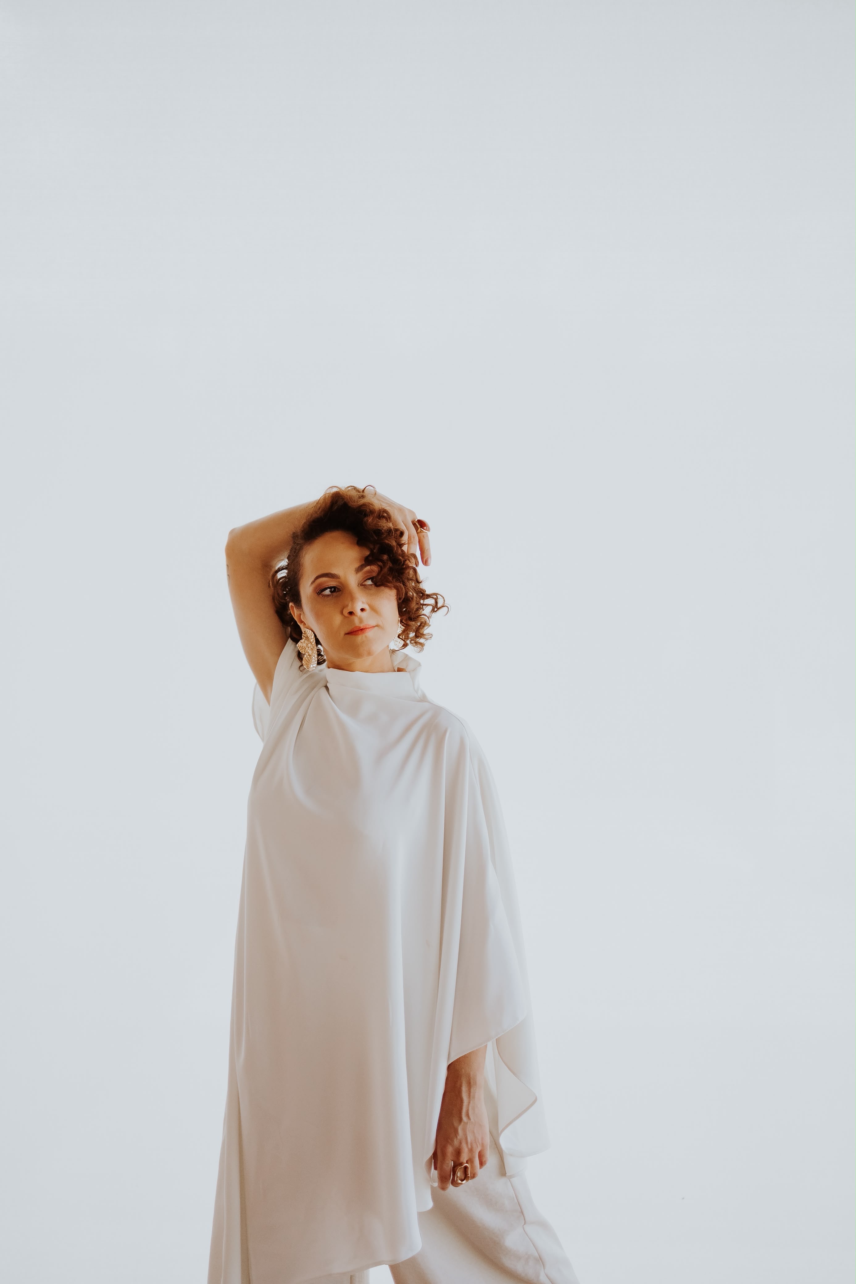 Ingrid Misat em uma pose de dança com um braço elevado, vista de corpo inteiro
